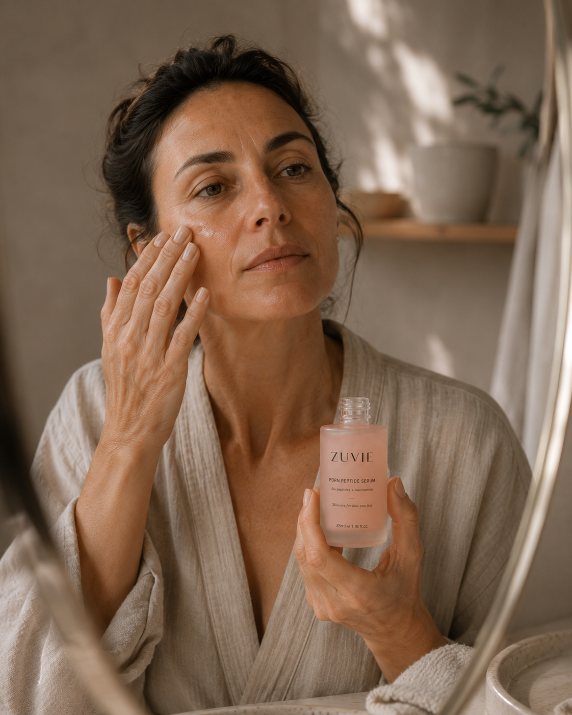 A woman applying serum to her cheek