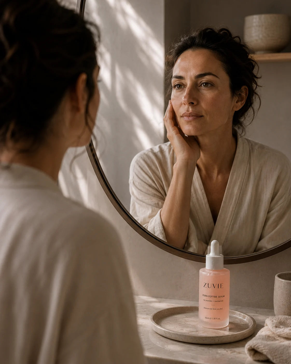 A woman taking a quiet moment beside her mirror